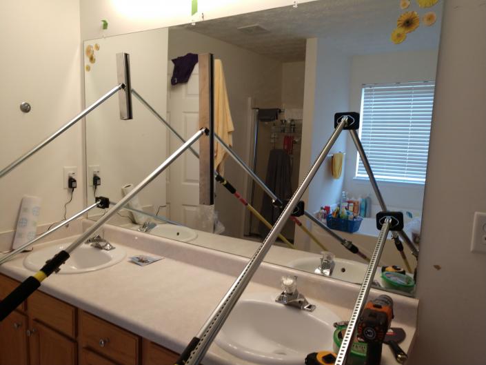 Double vanity bathroom mirror being installed.